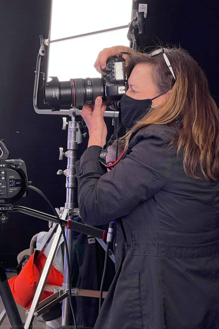 Female photographer taking pictures with a high quality camera on a Tucson video production set